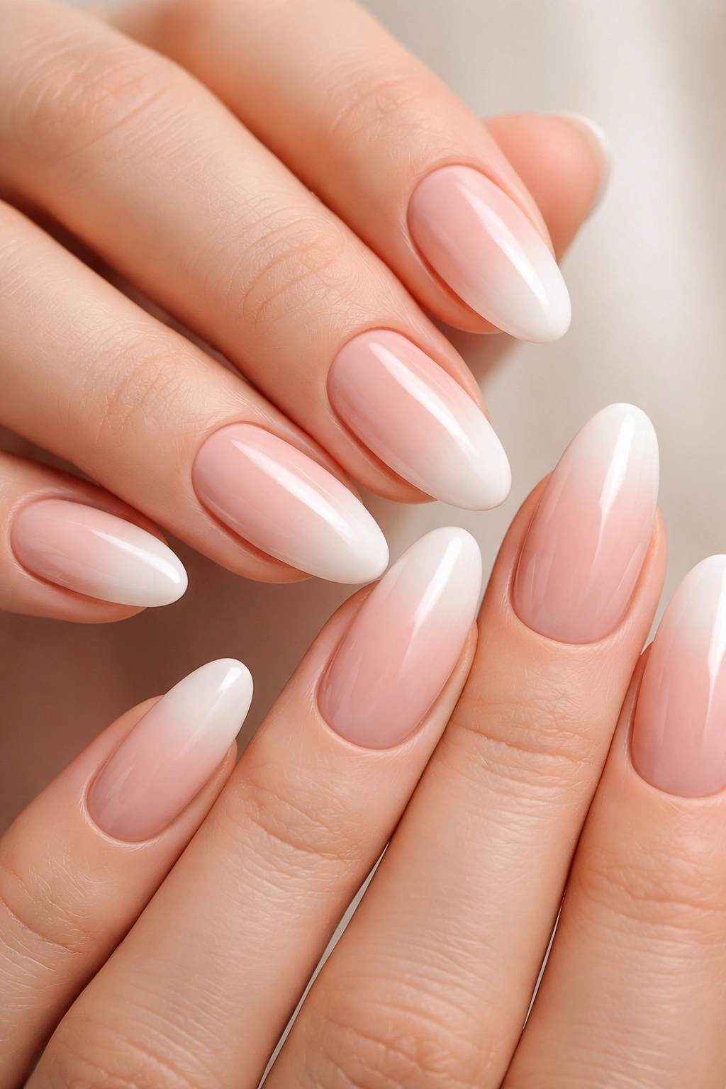 Close-up of hands with soft gradient ombré French tips on almond nails