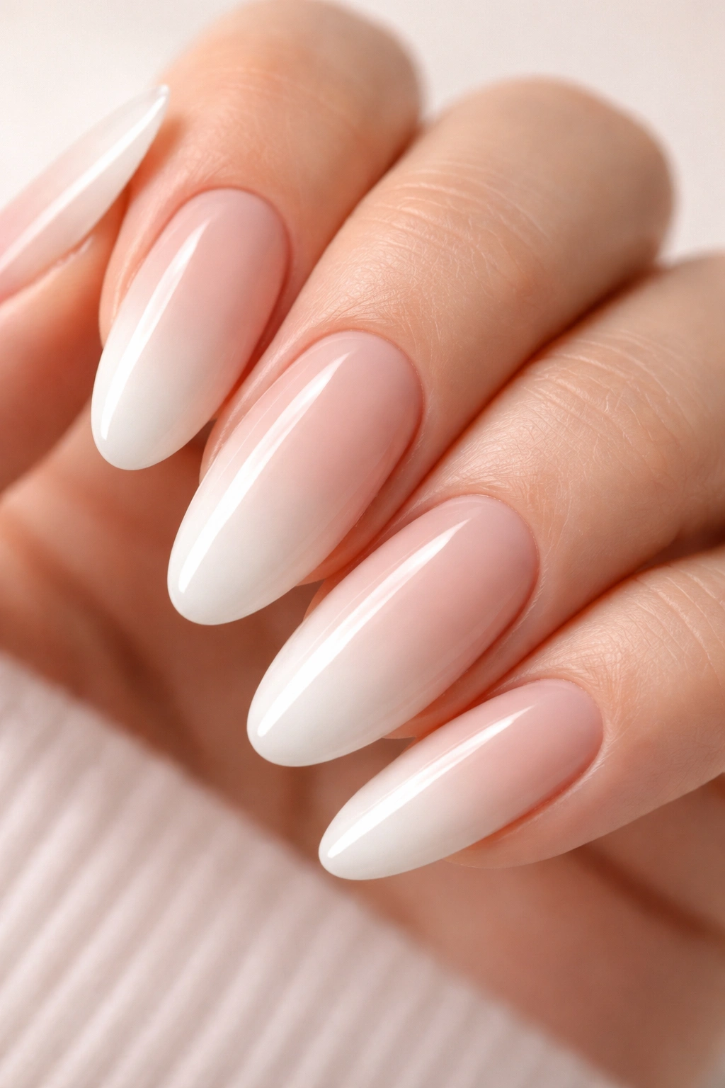 Close-up of nails with nude-to-white ombré gradient manicure