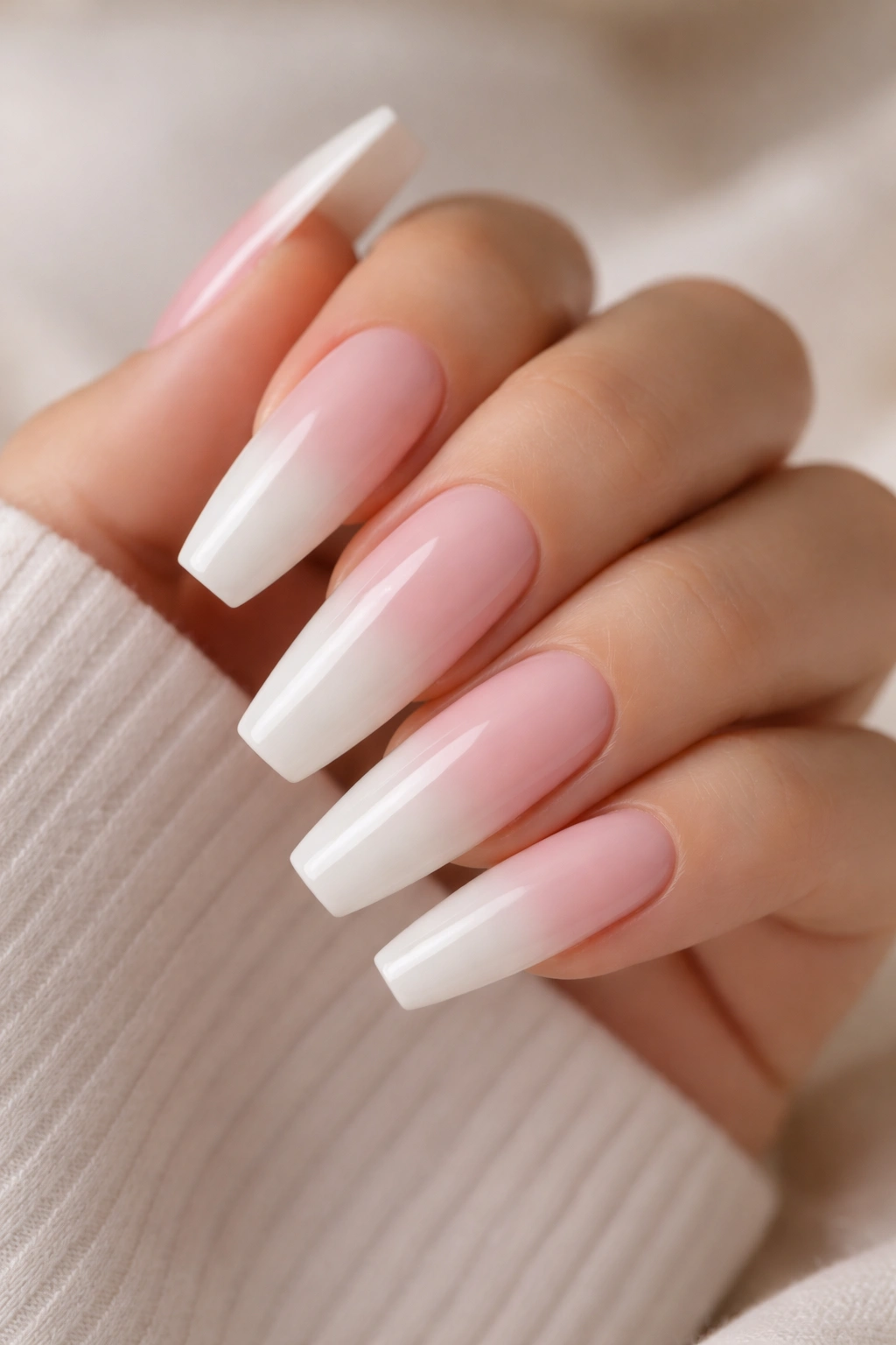 Ombré nails transitioning from milky white to soft blush