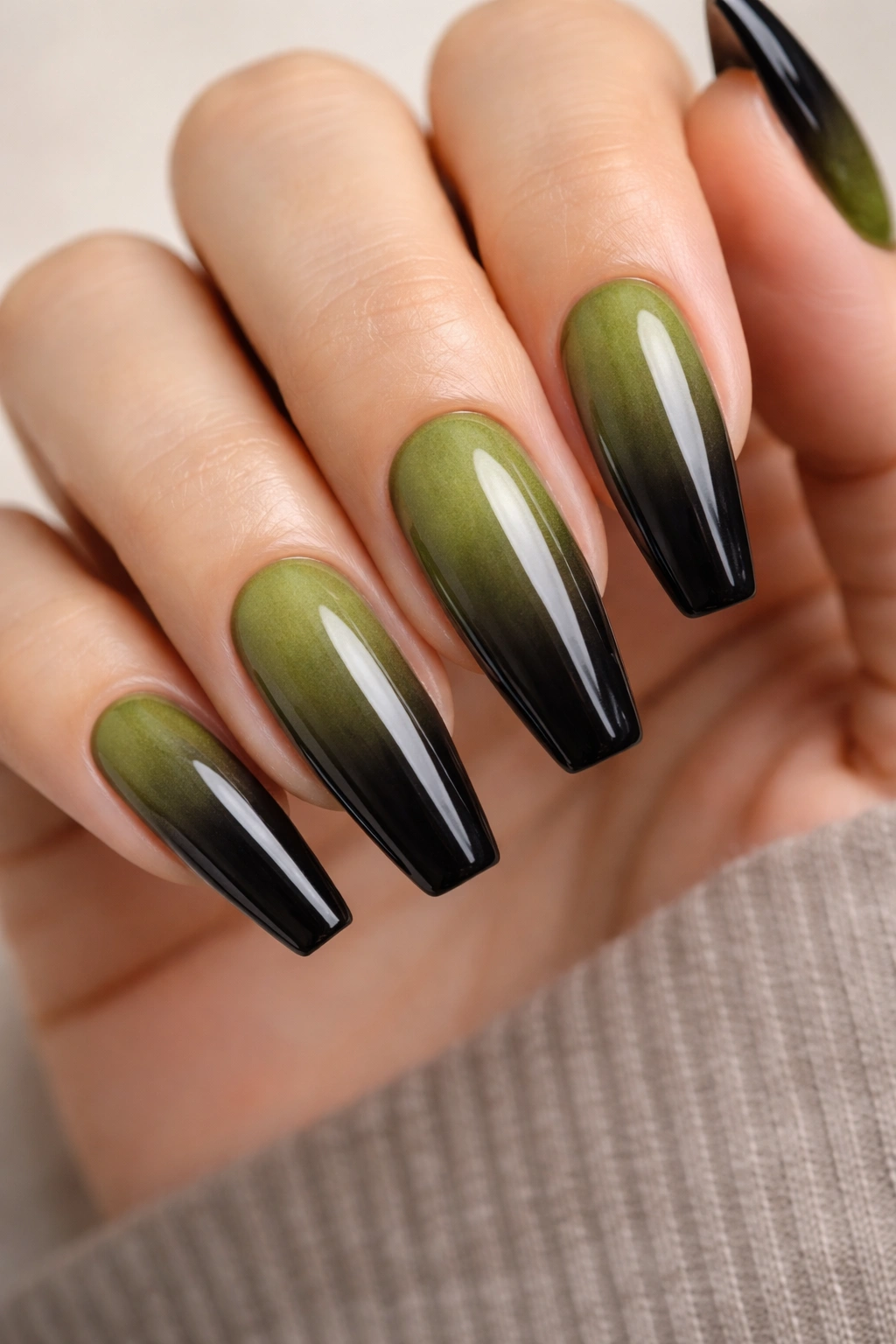 Close-up of moss-to-black ombre on long ballerina nails with smoky gradient and tapered tips