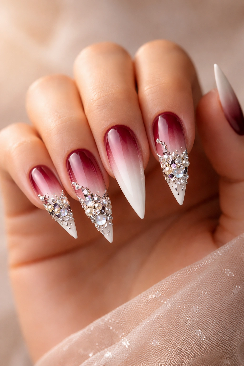 Ombre stiletto nails with 3D tip embellishments.