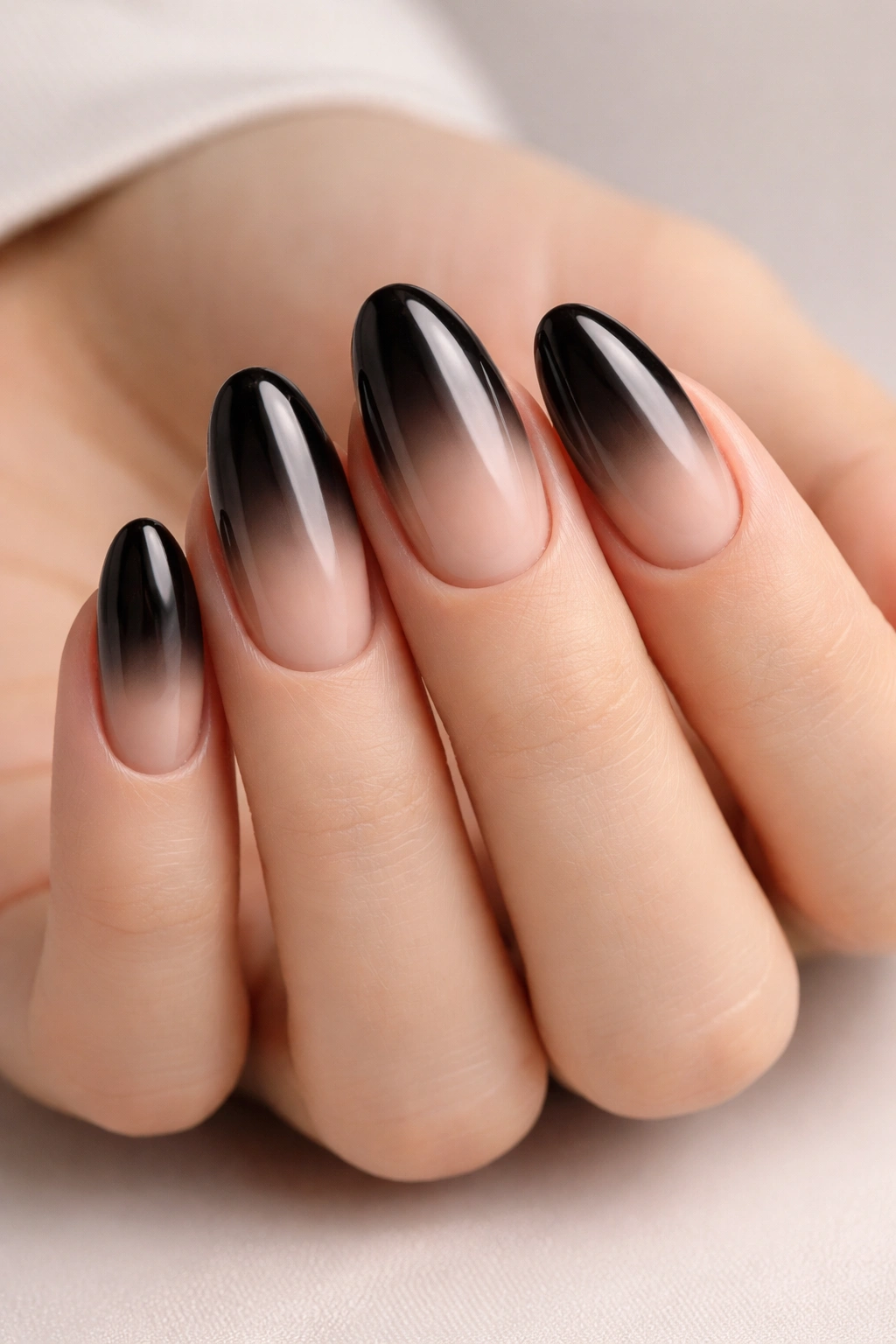 Close-up of black-to-nude ombre nails with a smooth gradient on a hand