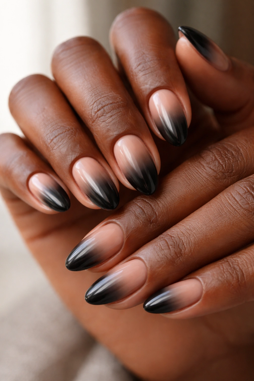 Ombre black to nude almond nails on dark skin