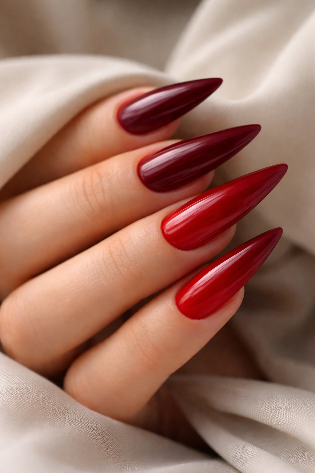 Close-up of red ombré nails from burgundy to bright red.