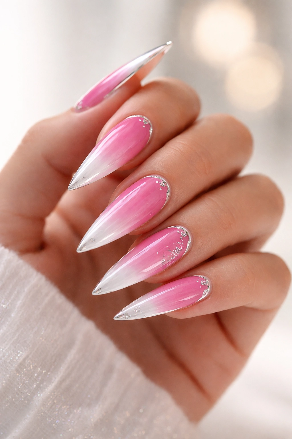 Gradient pink to white ombre stiletto nails with chrome accents close-up