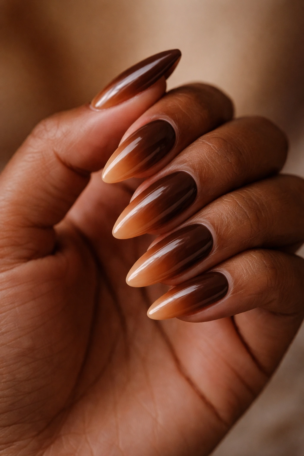 Almond nails in cocoa brown to caramel gradient with glossy finish.