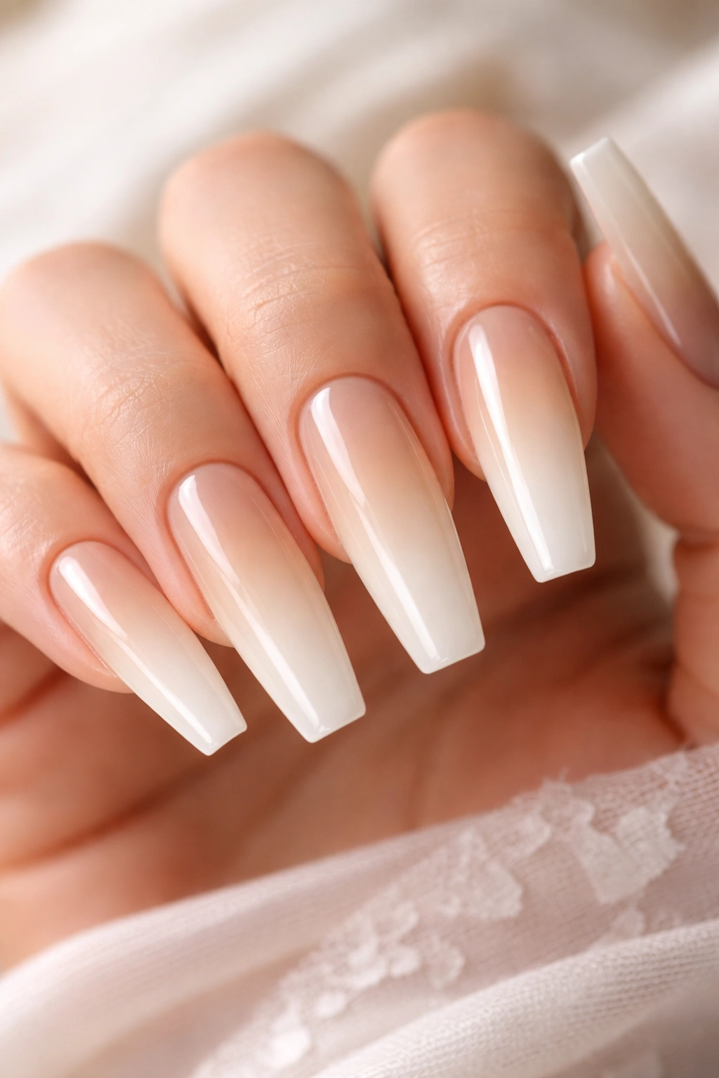 Close-up of coffin nails with champagne to ivory ombre gradient on a neutral background