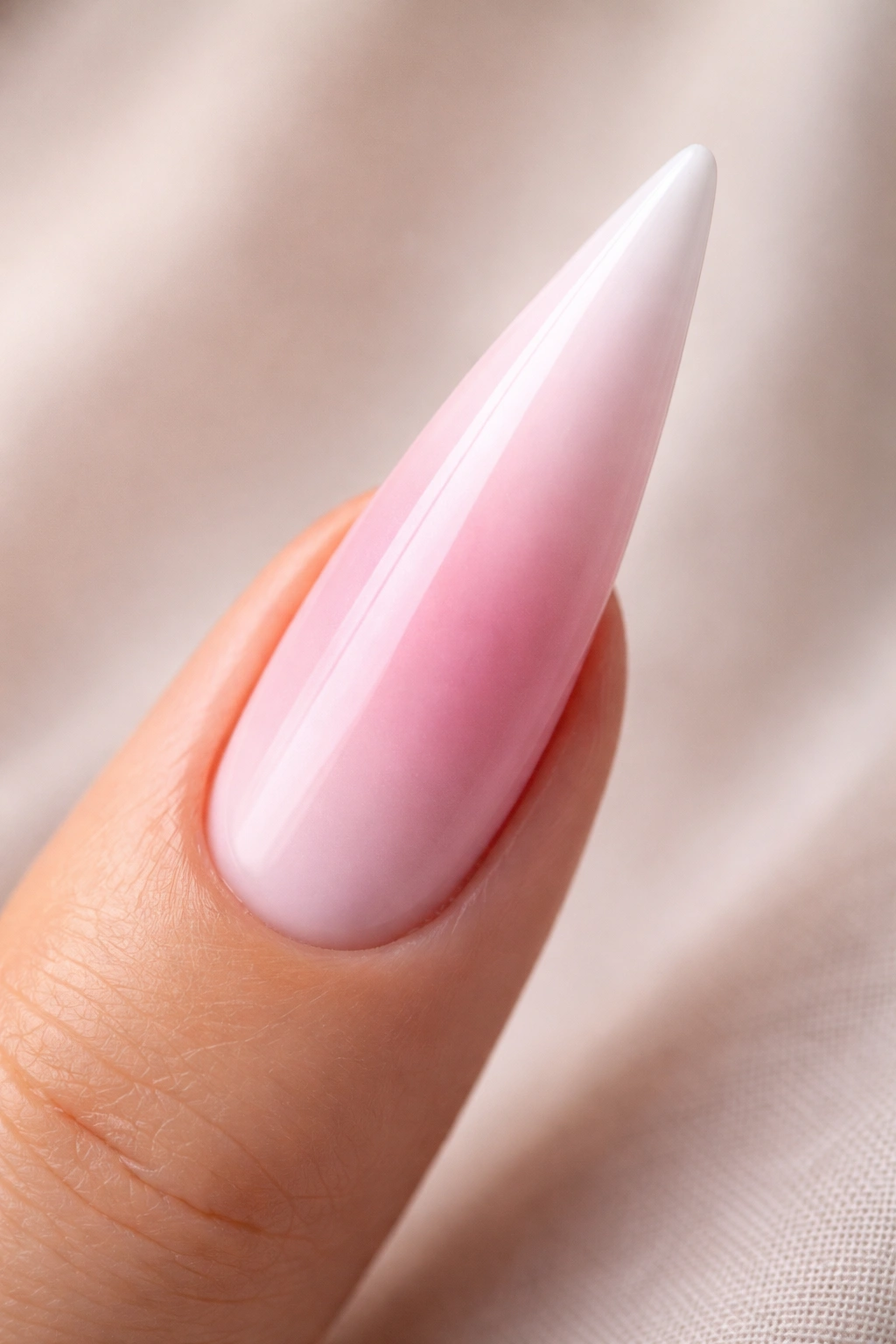 Close-up of a pink to white gradient stiletto nail
