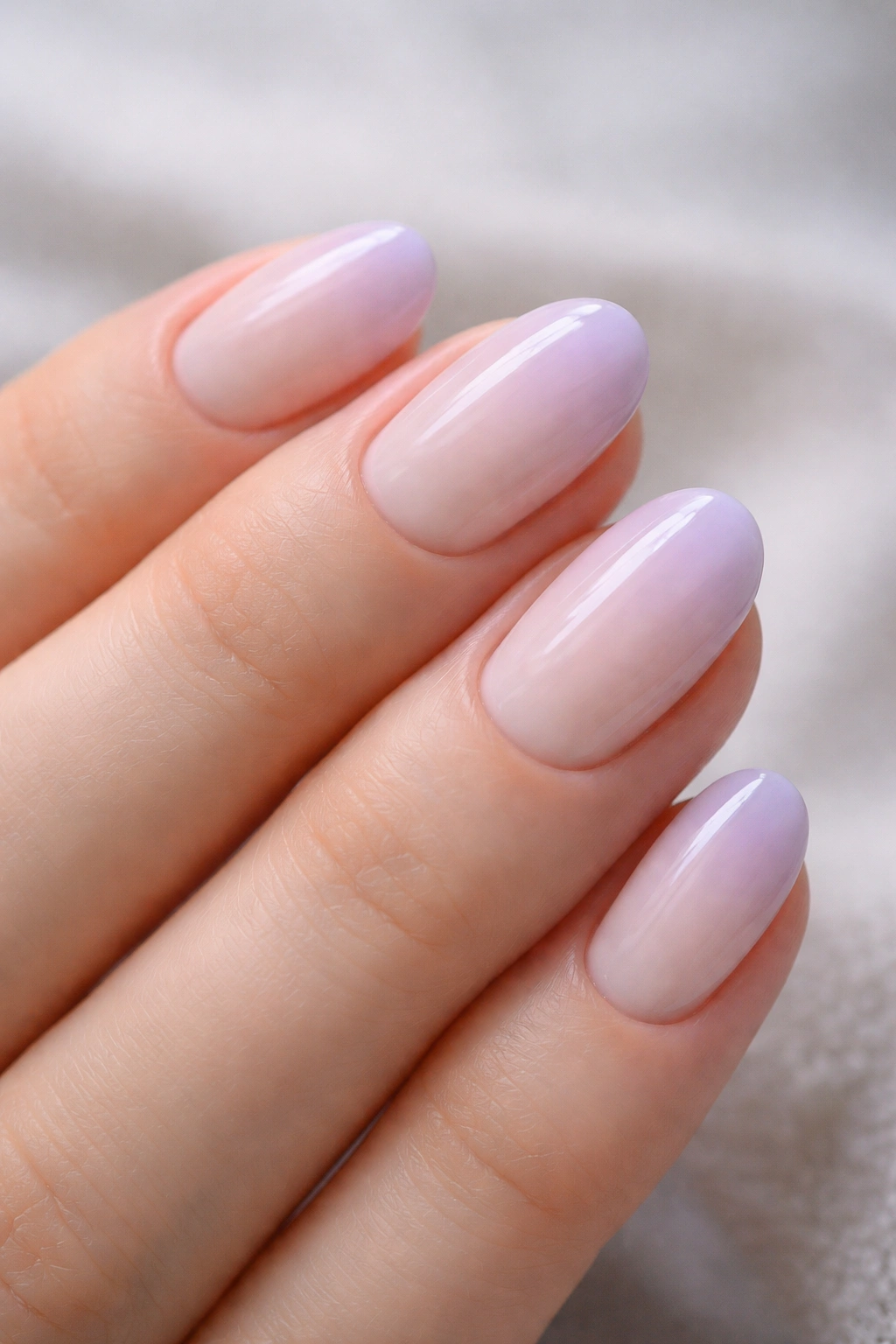 Close-up of short oval nails with lavender milk to lilac haze ombre