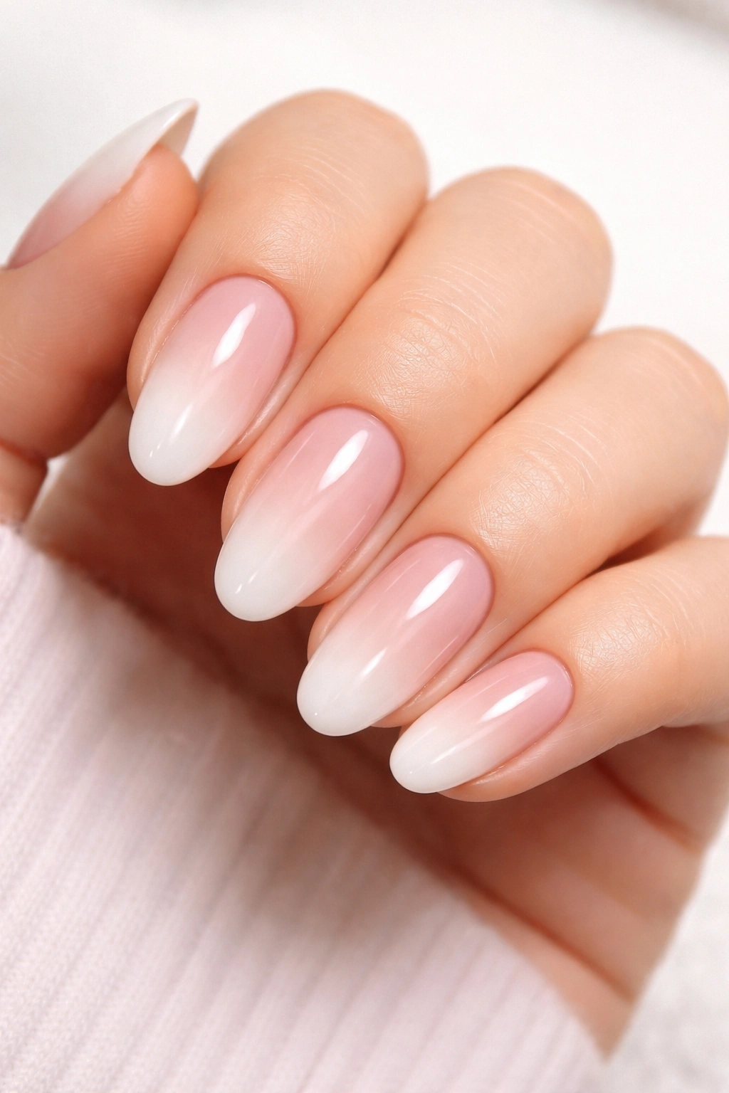 Close-up of a hand with well-maintained ombré nails and glossy shine