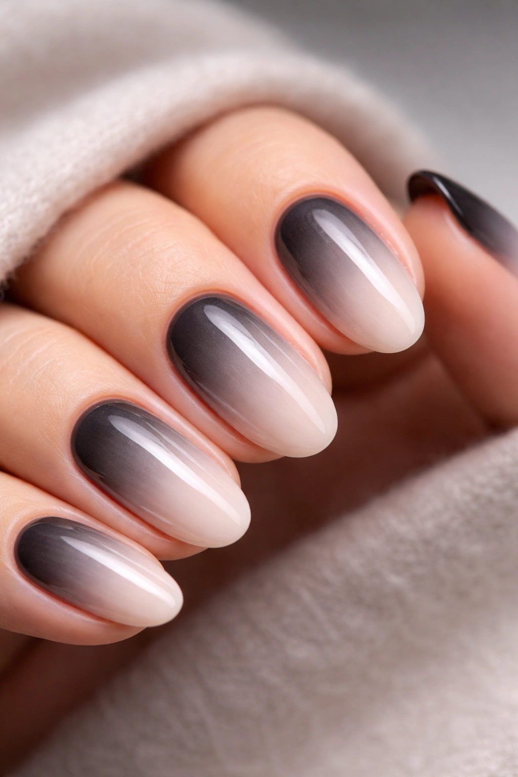 Close-up of monochrome ombre nails with gradient from dark to light