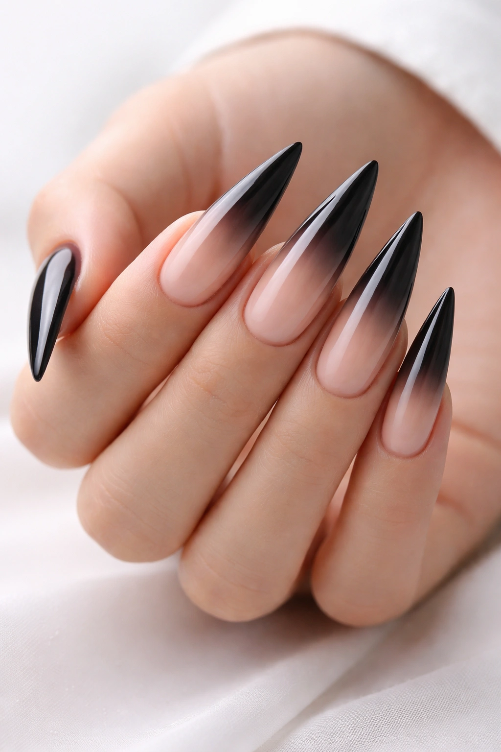 Nude-to-black ombre stiletto nails with seamless gradient