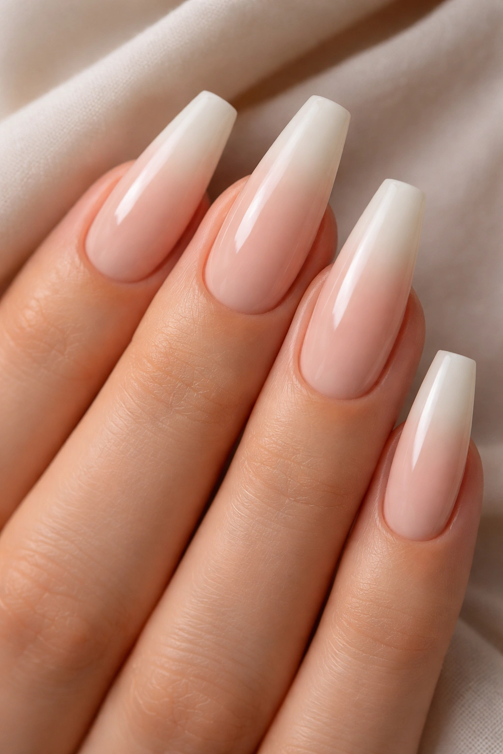 Close-up of nude-to-cream baby ombre on tapered ballerina nails