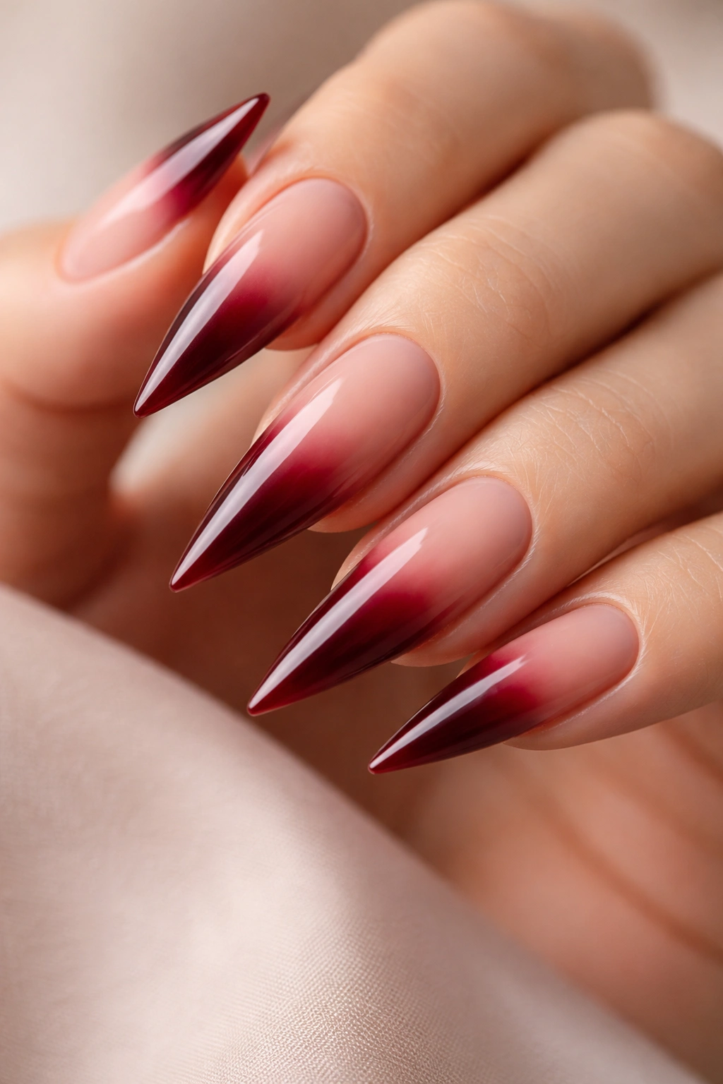 Close-up of nude-to-red ombré nails on stiletto shape
