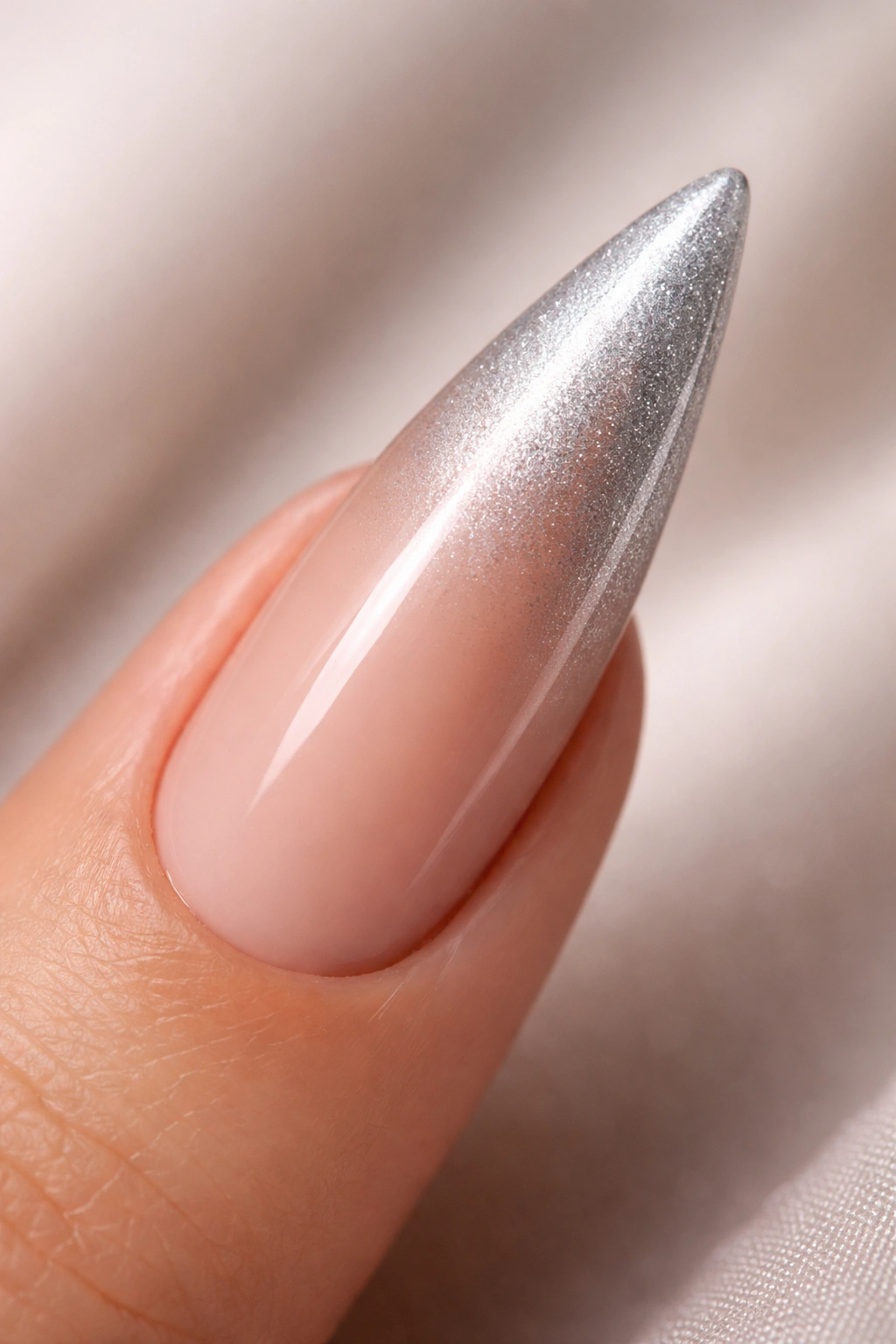 Nude-to-silver ombré stiletto nail with seamless gradient.