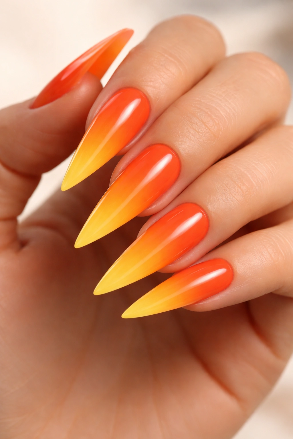 Close-up of ombre orange to yellow gradient on stiletto nails