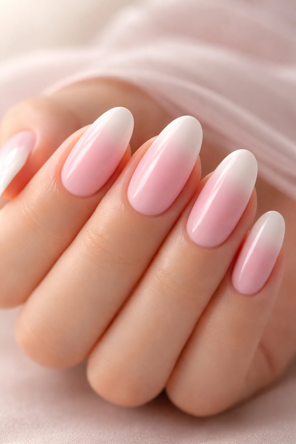 Close-up of ombré pastel pink to white oval nails