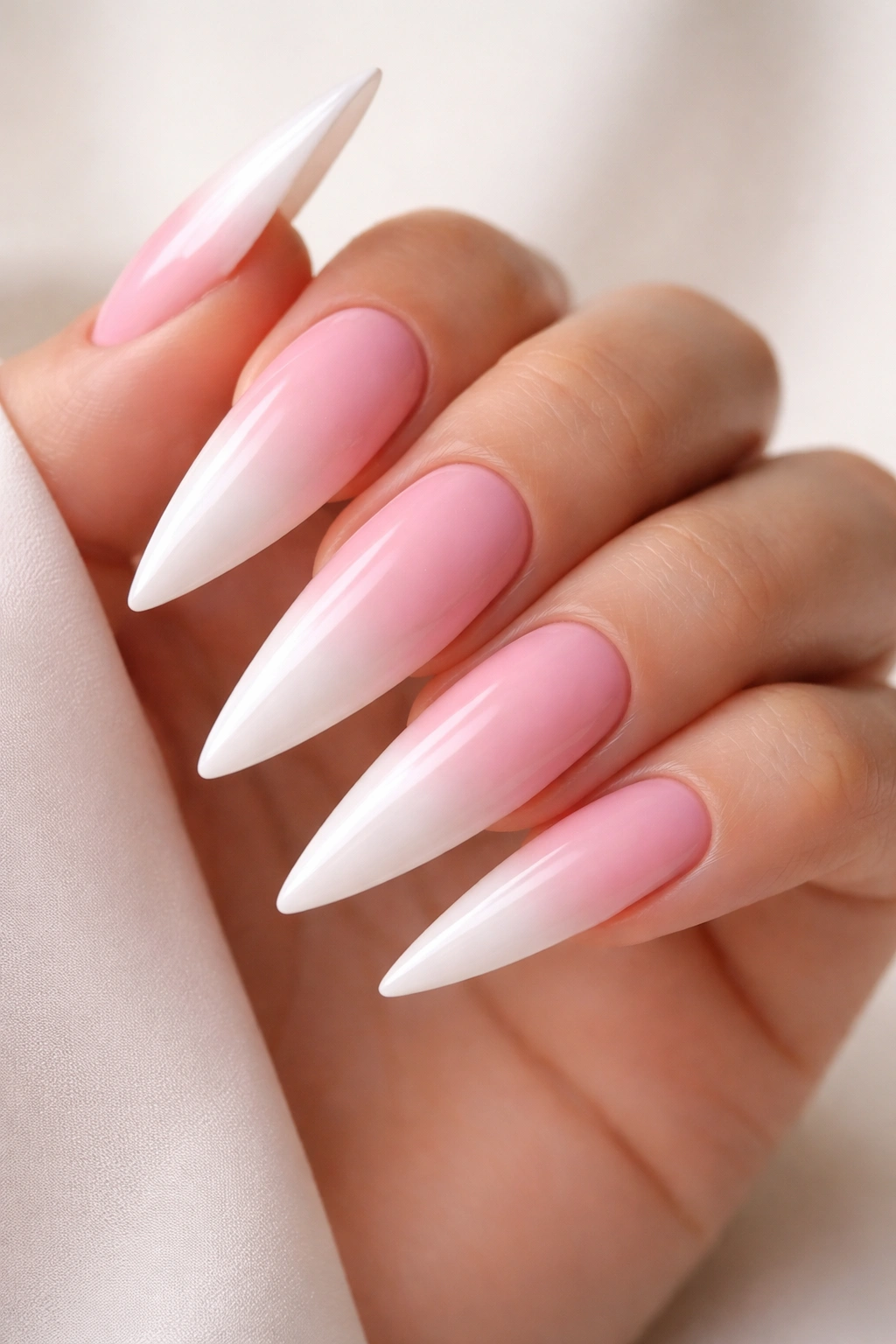 Close-up of pink to white ombré stilettos nails