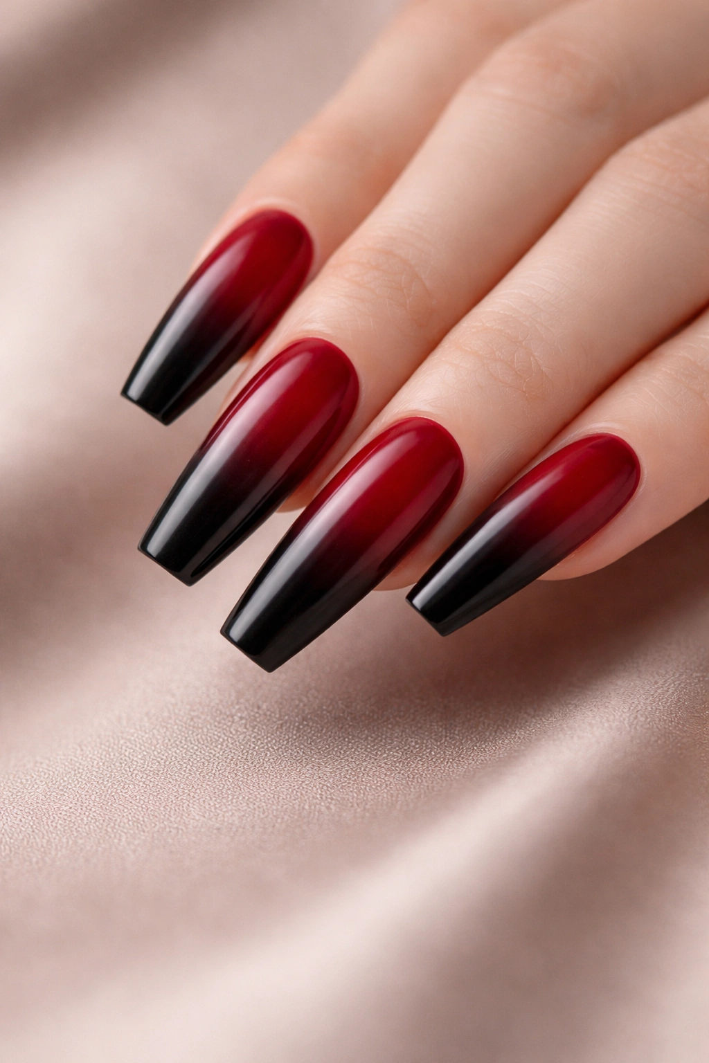 Close-up of coffin nails with deep red to black ombre gradient
