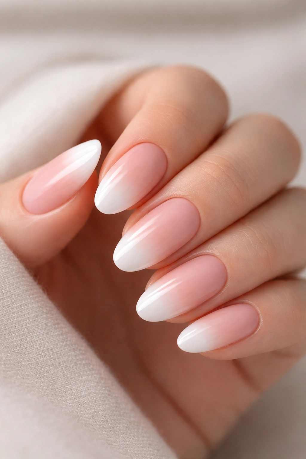 Close-up of nails with a pink-to-white ombré gradient (baby boomer) manicure