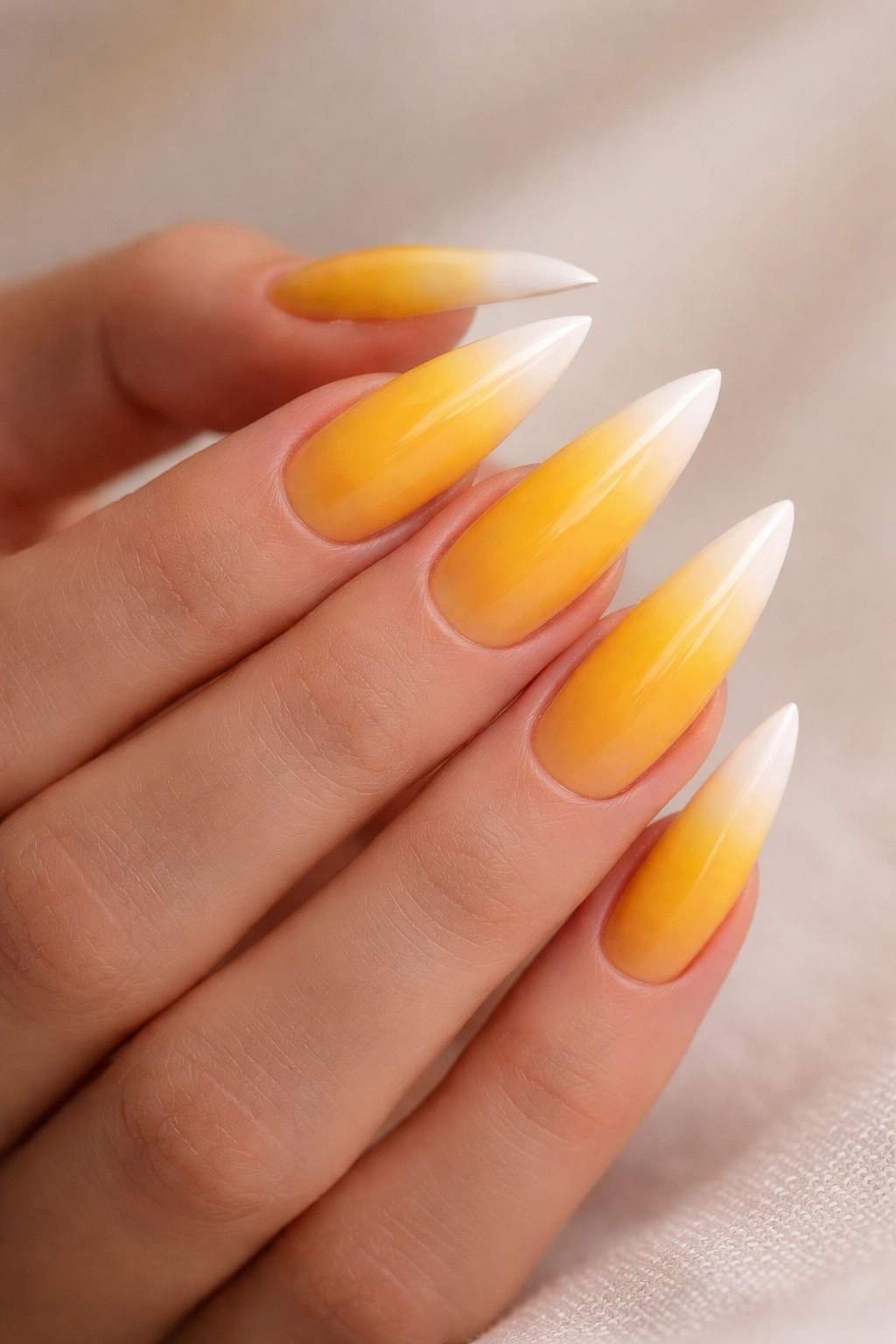 Ombre yellow to white stiletto nails in a close-up