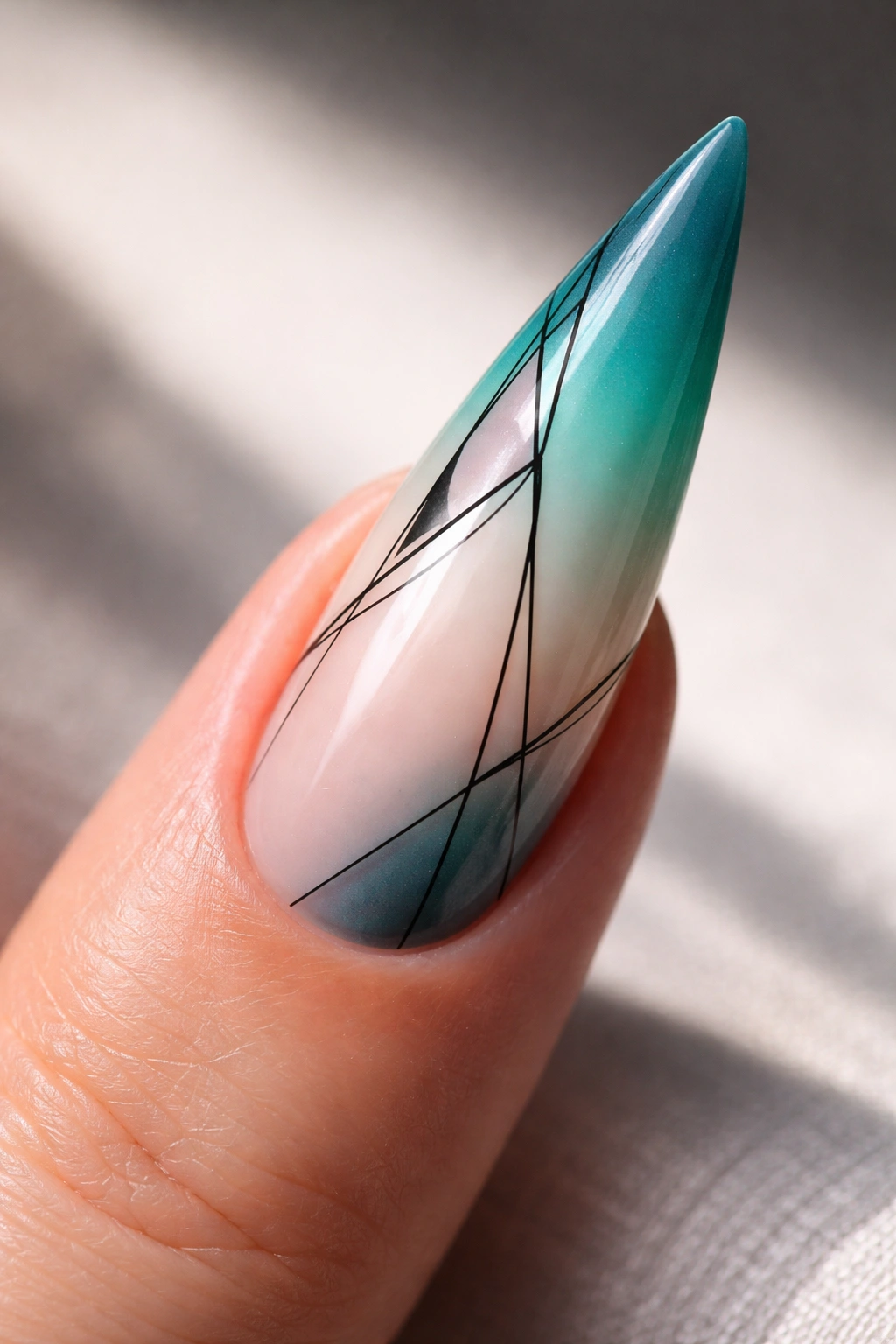 Stiletto nail with teal-to-white ombre, negative space, and fine line art