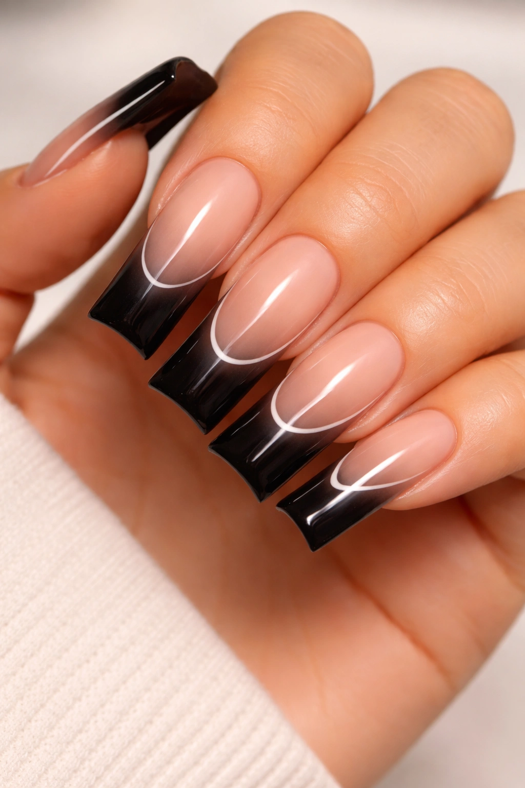 Nude to black ombré nails with minimal white detailing at the transition