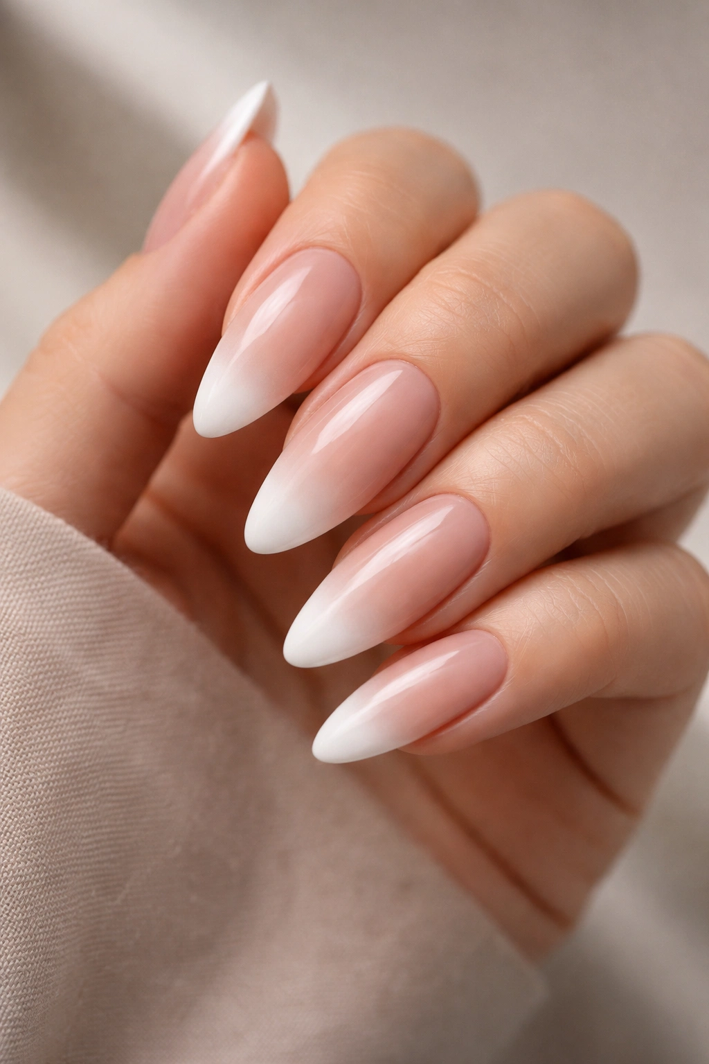 Nude-to-white ombre French on long almond nails.