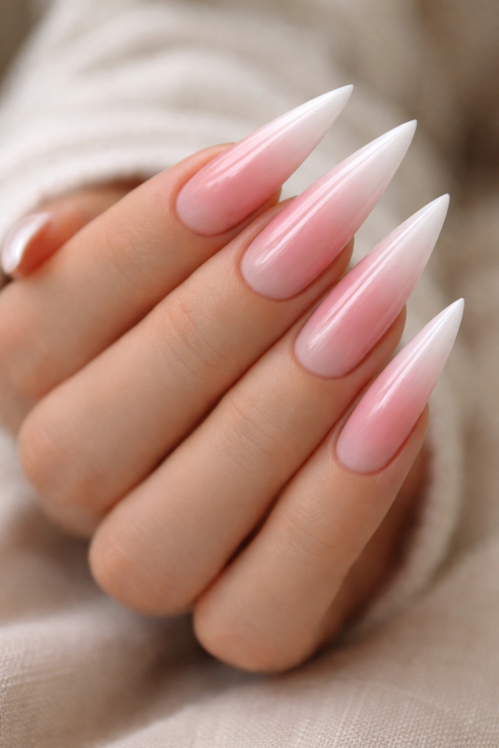 Close-up of three-color gradient pink nude white stilettos that elongate nails
