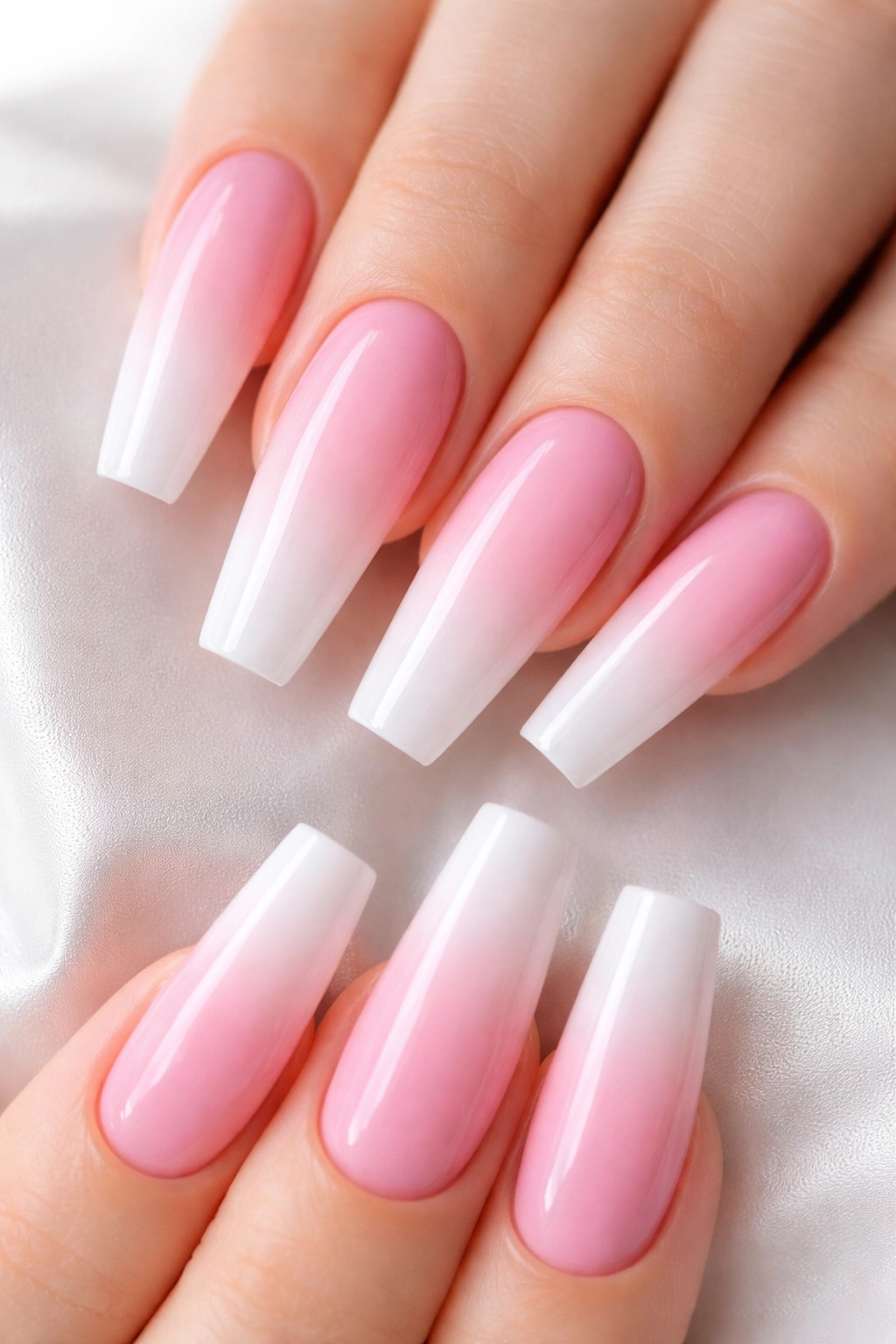 Close-up of long coffin nails with pink-to-white ombre gradient