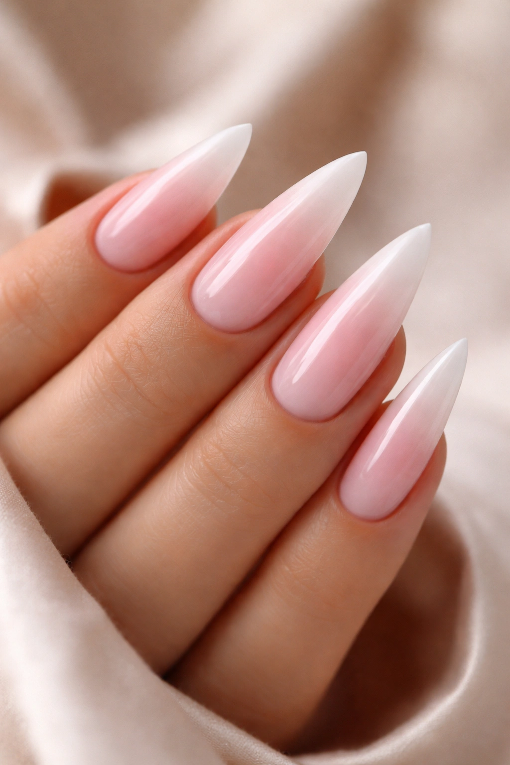 Close-up of soft pink to white ombré stiletto nails