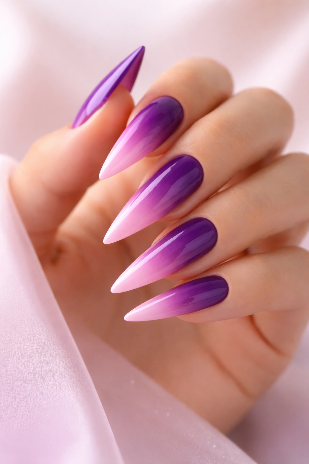 Close-up of ombré purple to pink gradient on long stiletto nails