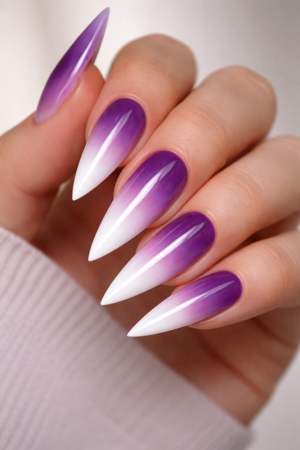 Close-up of ombré purple to white tips on stiletto nails