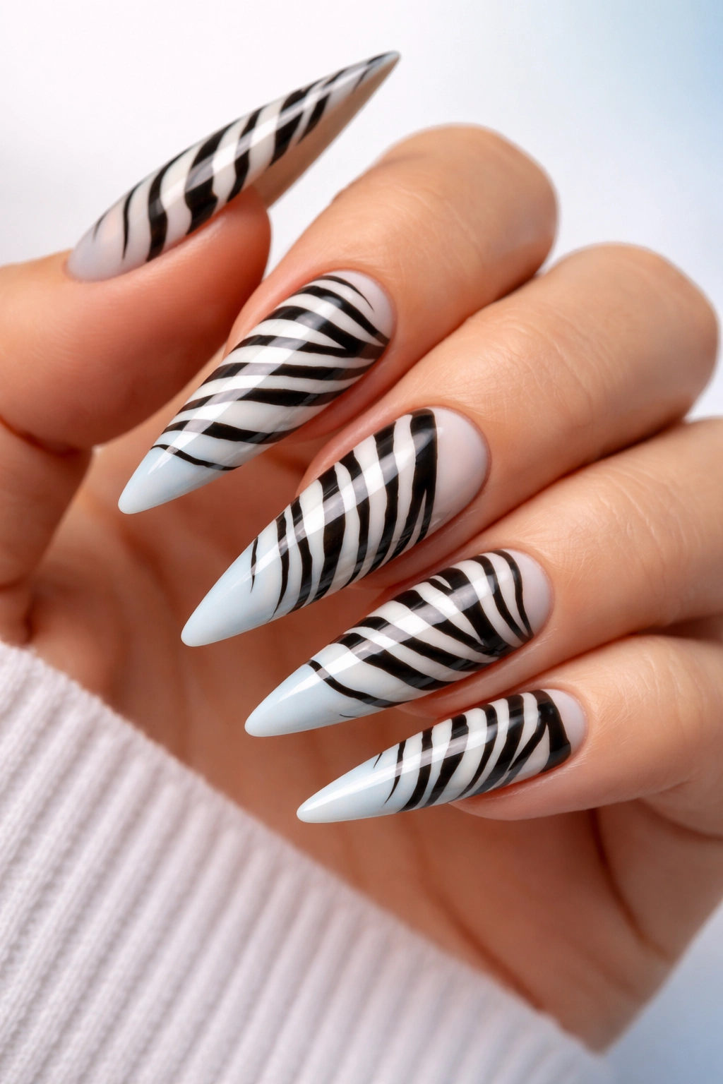 Stiletto nails with zebra stripes over gradient background