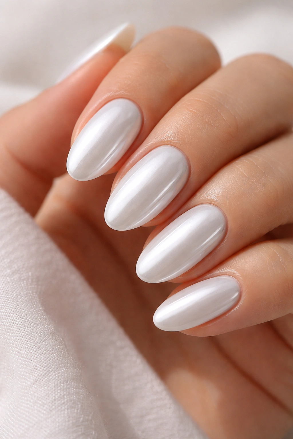 Close-up of short almond nails fully covered in opaque white chrome