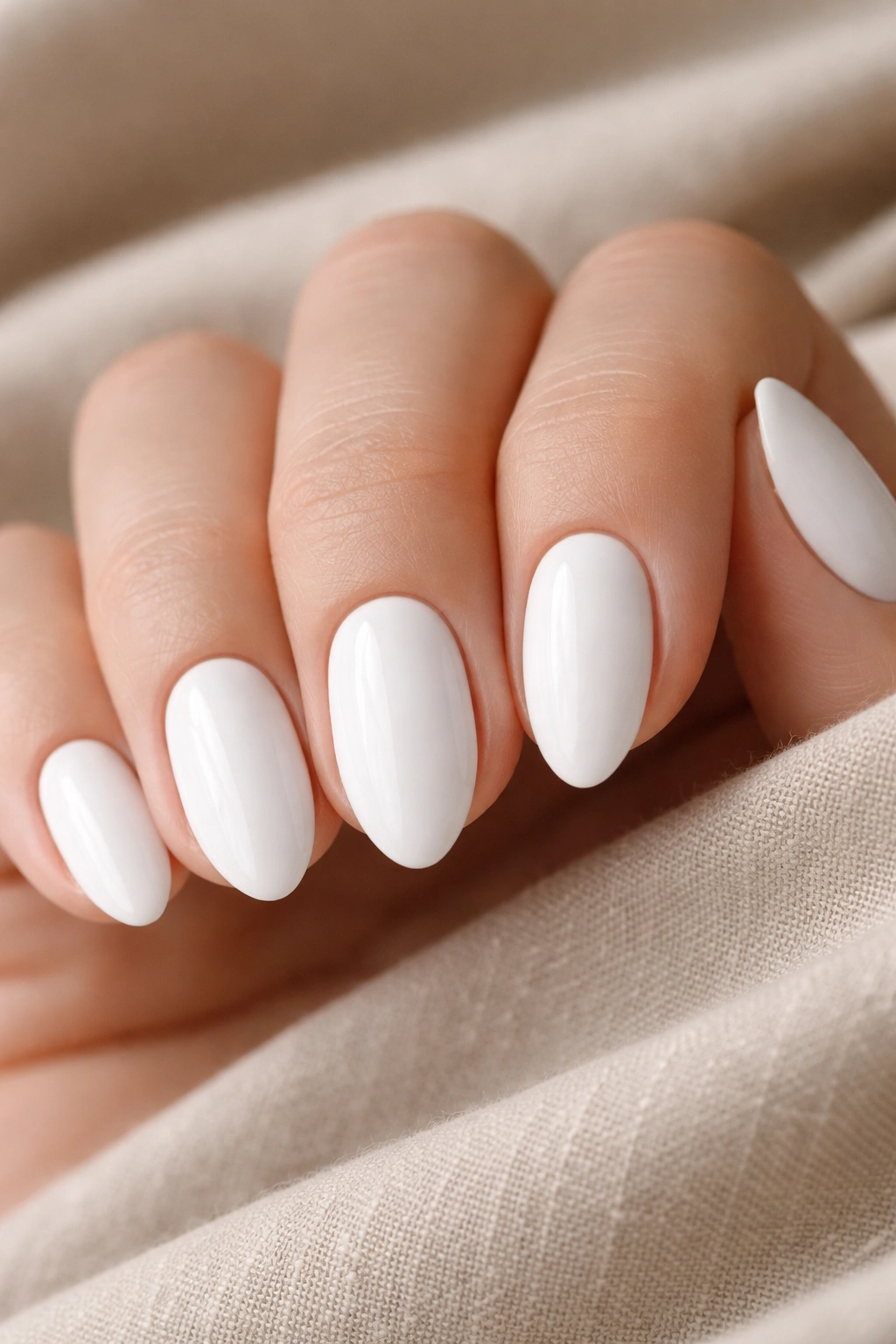 Close-up of opaque white almond nails on short tips with glossy finish
