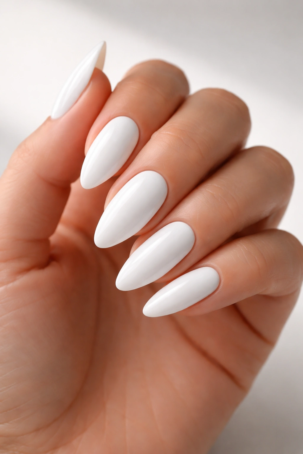 Close-up of bright opaque white almond nails with crisp, even polish
