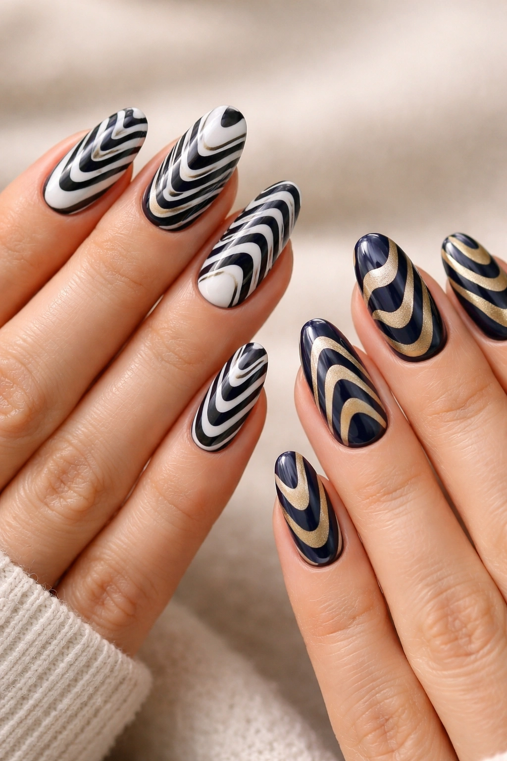 Close-up of two hands with optical illusion nail designs in black-white and navy-gold