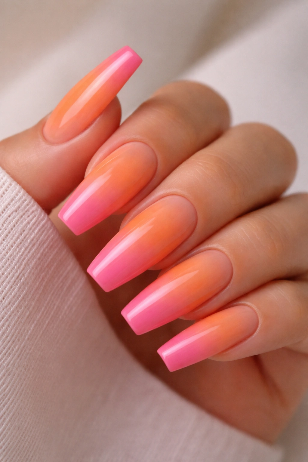 Orange to pink sunset gradient on long ballerina nails with glossy finish