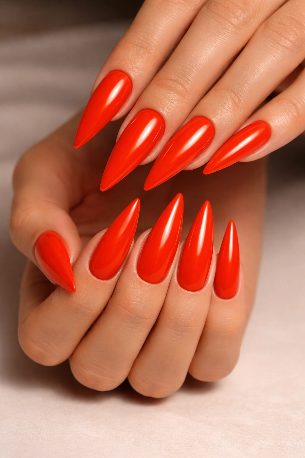 Hot orange-red stilettos with glossy finish on neutral background