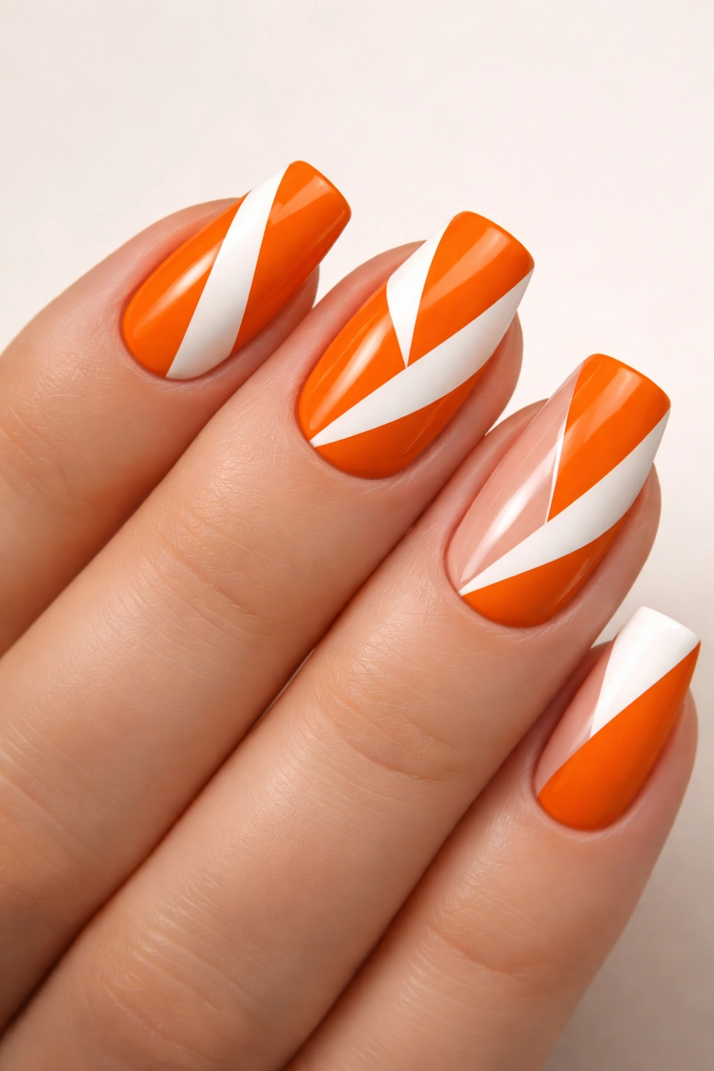 Close-up of orange and white geometric nail art