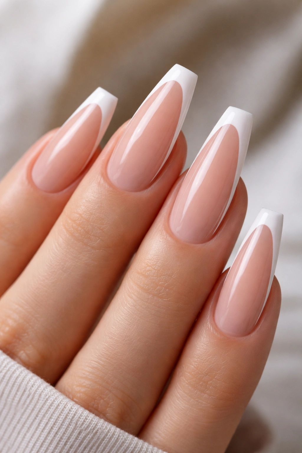 Close-up of outline French nails with thin white border around tip on nude base
