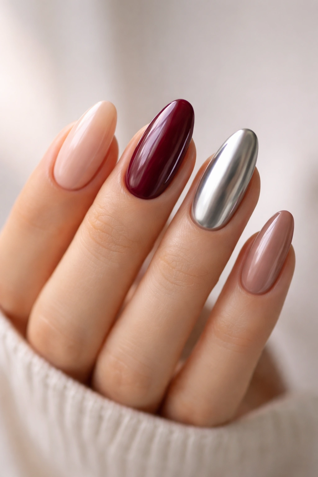 Close-up of a hand with long oval nails in multiple finishes demonstrating choices