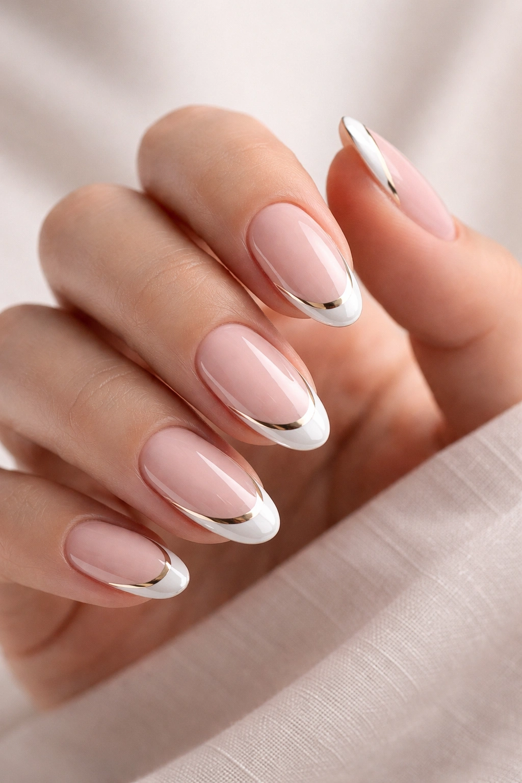 Close-up of oval nails with modern twists on a neutral background.