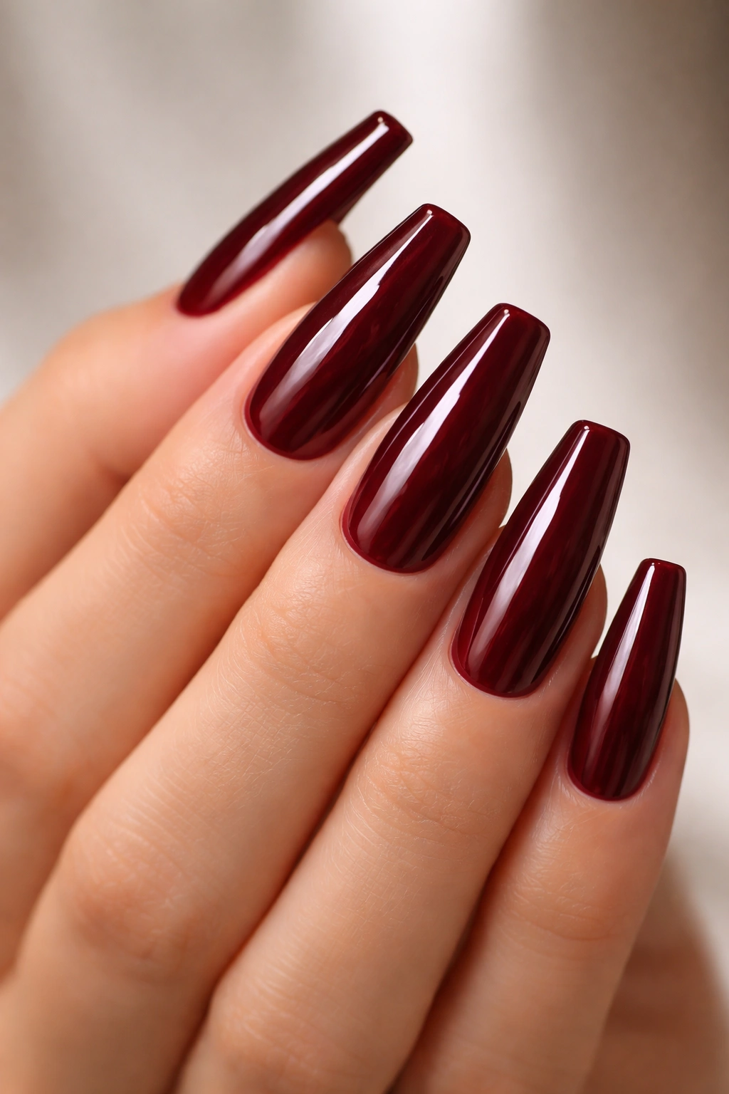 Close-up of coffin nails in deep oxblood red with a glossy finish