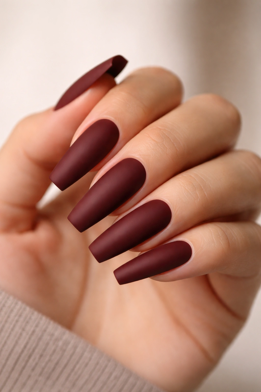 Long ballerina nails in oxblood matte finish with crisp edges
