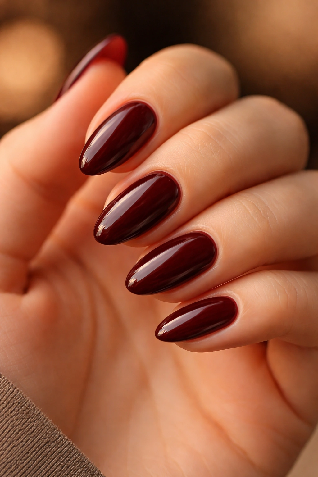 Close-up of oxblood almond nails on a hand