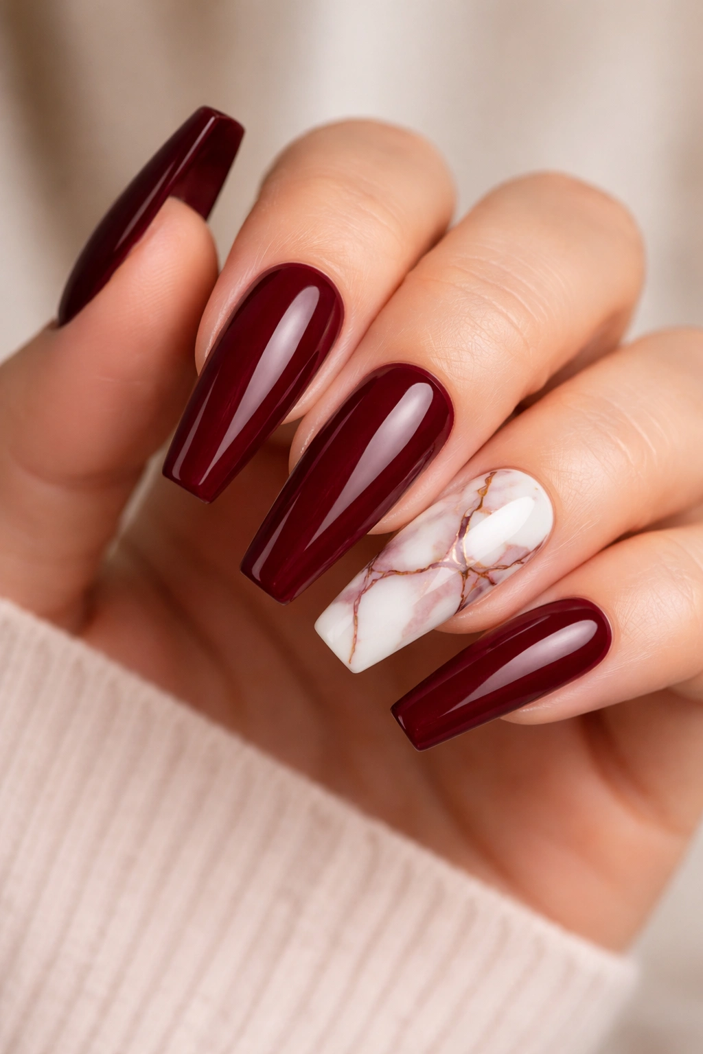 Oxblood nails with white marble accent on ring finger