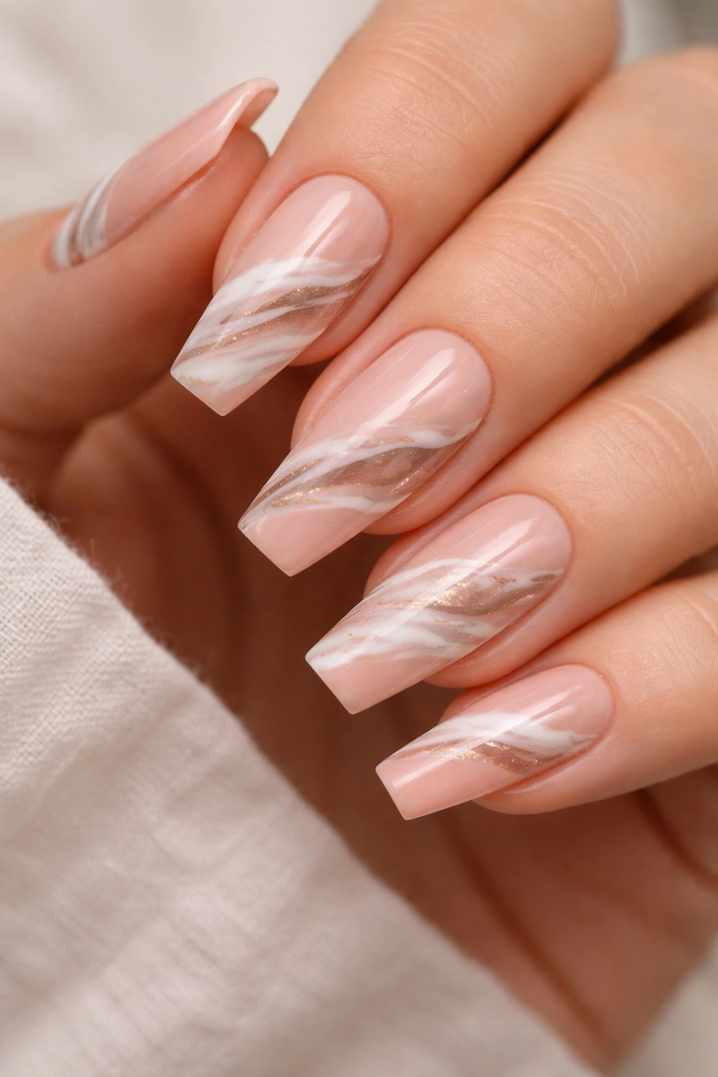 Close-up of pale coral coffin nails with negative-space marble swirls