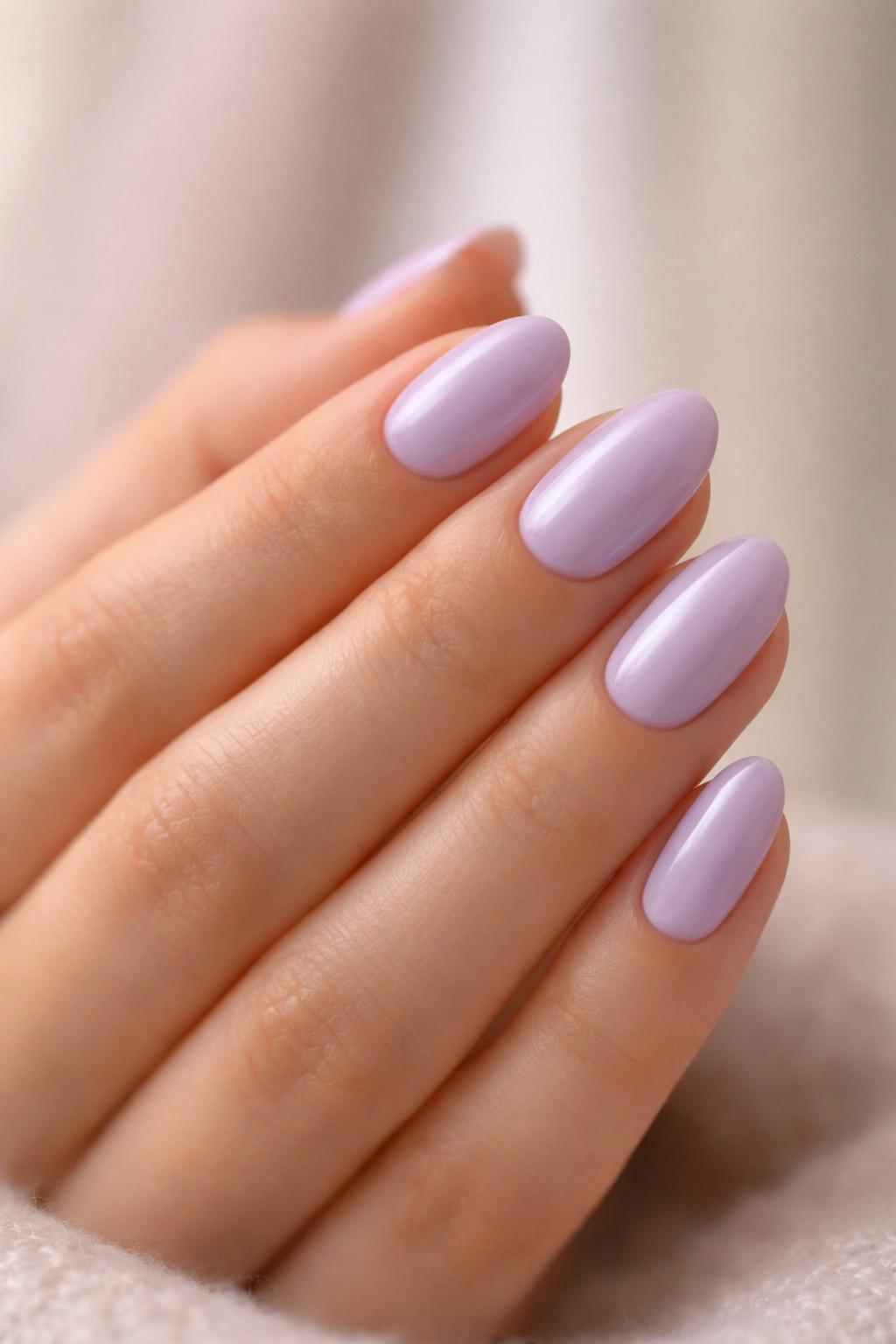 Close-up of pale lavender almond nails on short nails with soft studio lighting